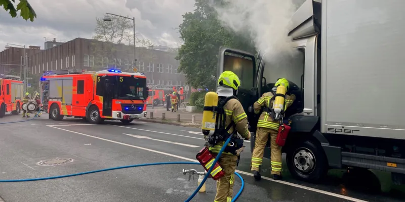 Feuerwehrleute l&ouml;schen einen brennenden LKW.